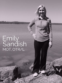 Emily Sandish, MOT, OTR/L, standing on rocks by a lake in a black and white portrait