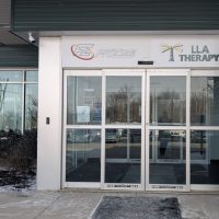 Glass entrance doors of an LLA Therapy office building
