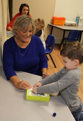 Therapist and a boy working together on a table-top activity
